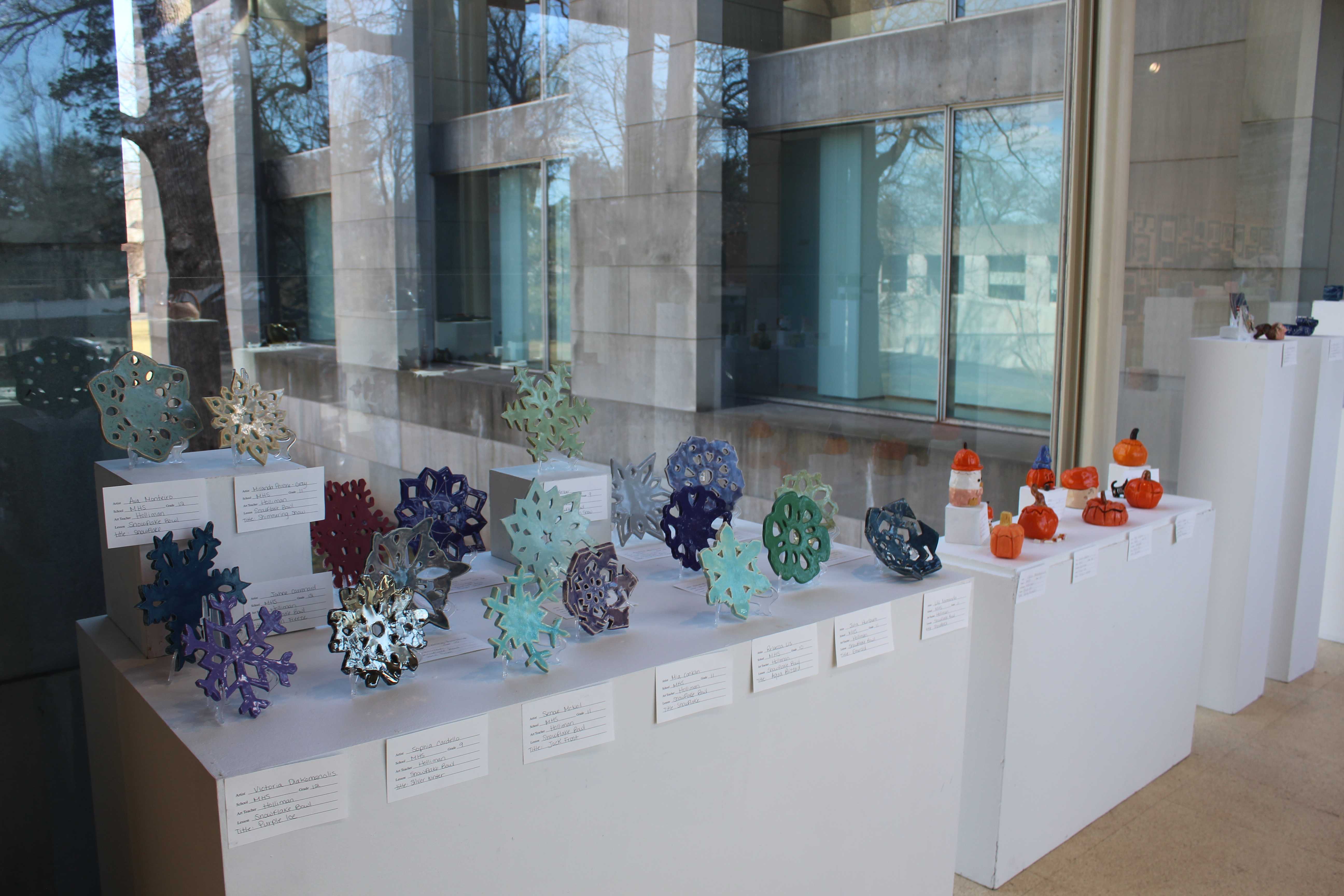 Pieces of student pottery on display, featuring pumpkins and snowflakes, for the respective seasons